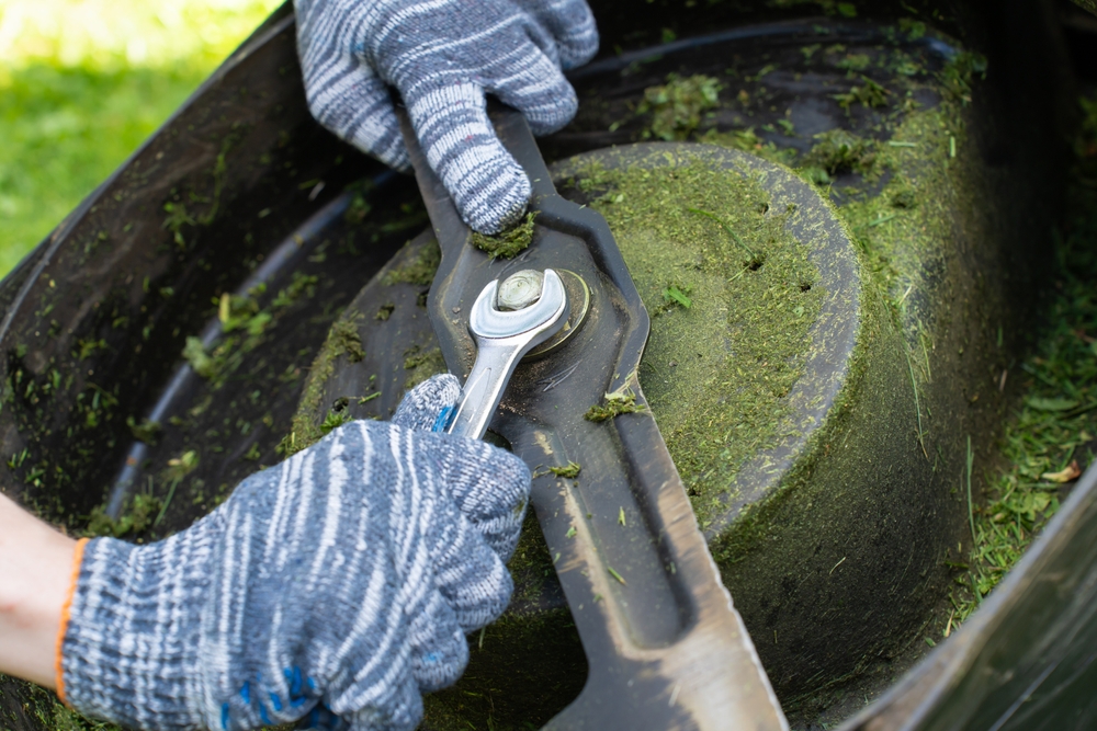 Hands,In,Gloves,Adjusting,Blade,On,Four-wheel,Lawn,Mower,,Diy